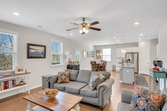 living room featuring recessed lighting, visible vents, light wood-style floors, ceiling fan, and baseboards