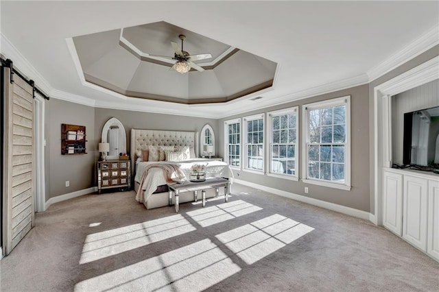 carpeted bedroom featuring ceiling fan, ornamental molding, a barn door, and a raised ceiling