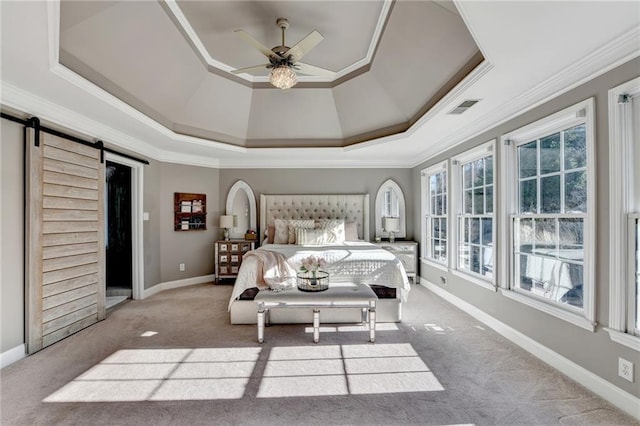 carpeted bedroom featuring crown molding, a raised ceiling, ceiling fan, and a barn door