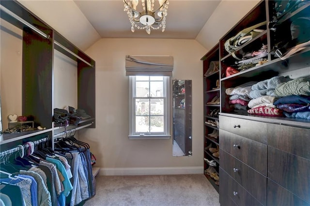 spacious closet with vaulted ceiling, a chandelier, and carpet