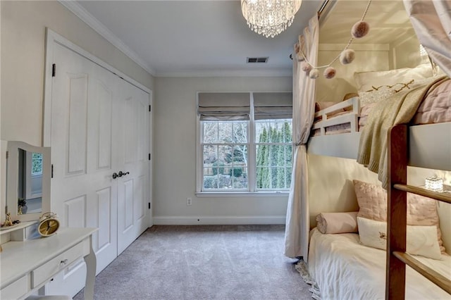 carpeted bedroom featuring crown molding, a closet, and a notable chandelier