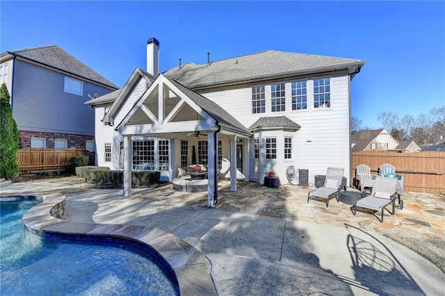 back of house with ceiling fan, a fenced in pool, and a patio