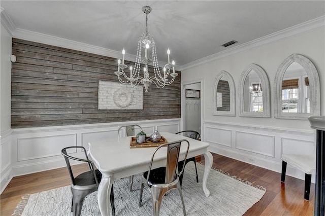 dining room with dark wood-type flooring, crown molding, and a chandelier