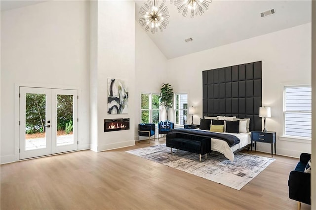 bedroom featuring high vaulted ceiling, visible vents, wood finished floors, and access to outside