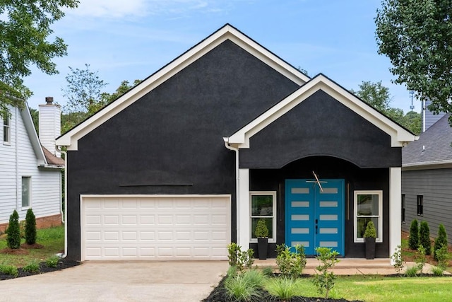 view of front of property featuring stucco siding, a garage, and driveway