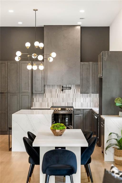 kitchen featuring a breakfast bar area, a kitchen island, appliances with stainless steel finishes, light wood-type flooring, and backsplash