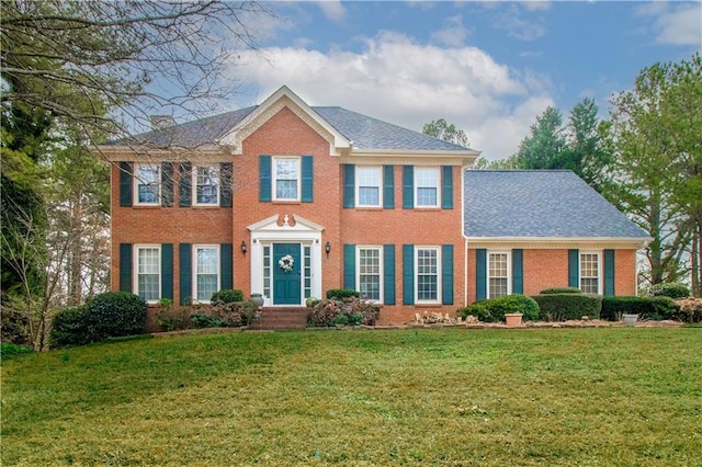 colonial-style house featuring a front yard