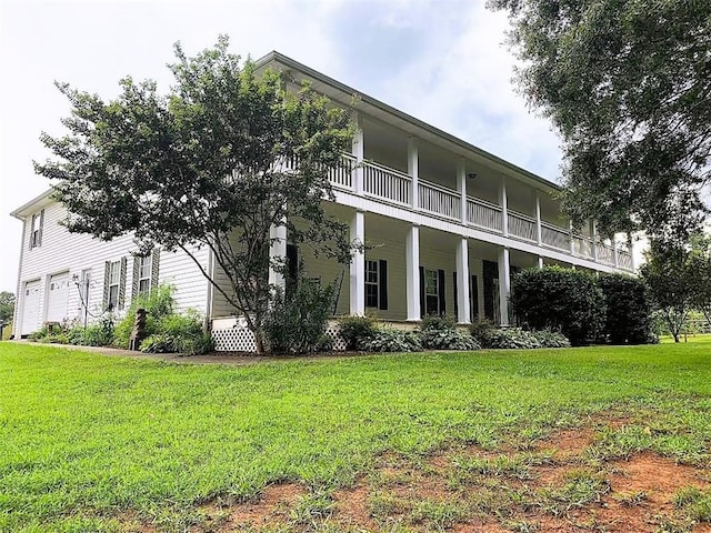 rear view of house featuring a balcony and a lawn