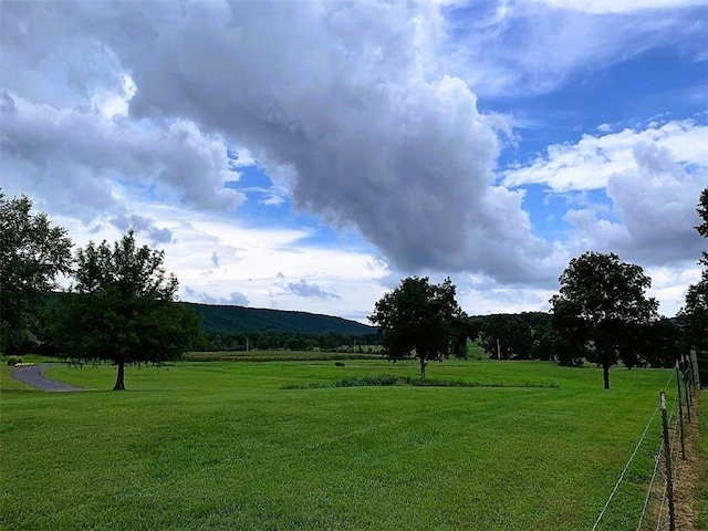 surrounding community featuring a yard and a rural view