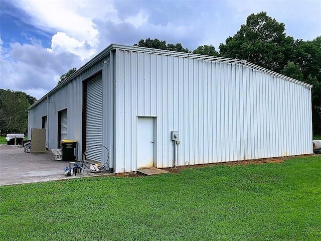 view of outdoor structure featuring a lawn and a garage