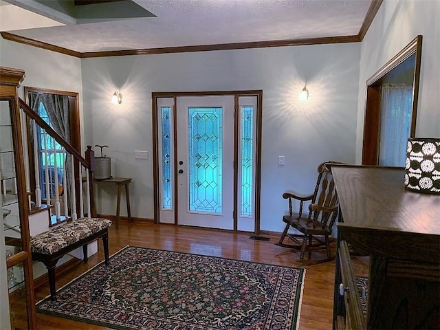 foyer with crown molding, a textured ceiling, and hardwood / wood-style flooring