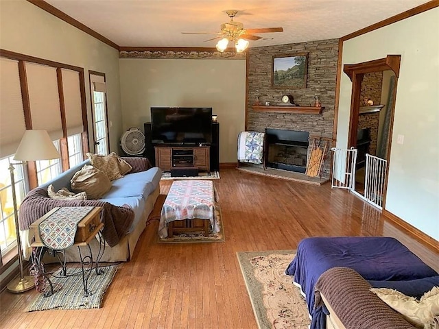 living room with a fireplace, ceiling fan, and light wood-type flooring