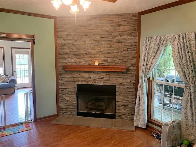 unfurnished living room featuring ceiling fan, a stone fireplace, and dark wood-type flooring