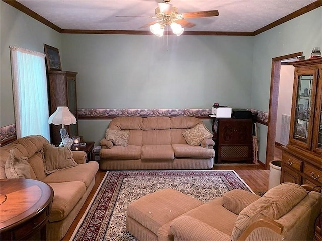 living room with ornamental molding, wood-type flooring, and ceiling fan