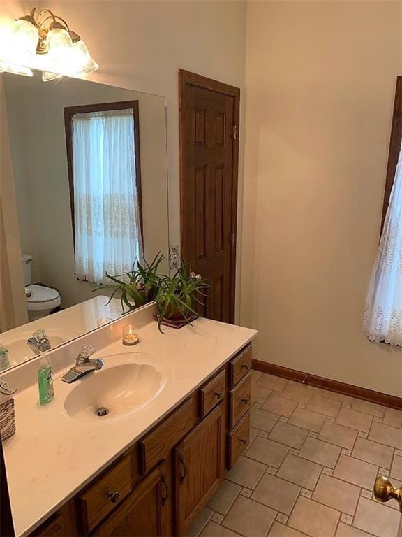 bathroom featuring toilet, tile floors, and vanity