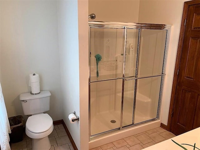 bathroom featuring tile flooring, toilet, and an enclosed shower