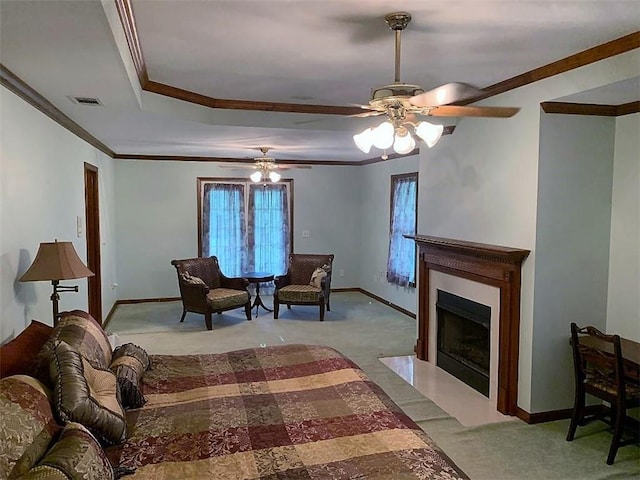 carpeted living room with a raised ceiling, ceiling fan, and crown molding