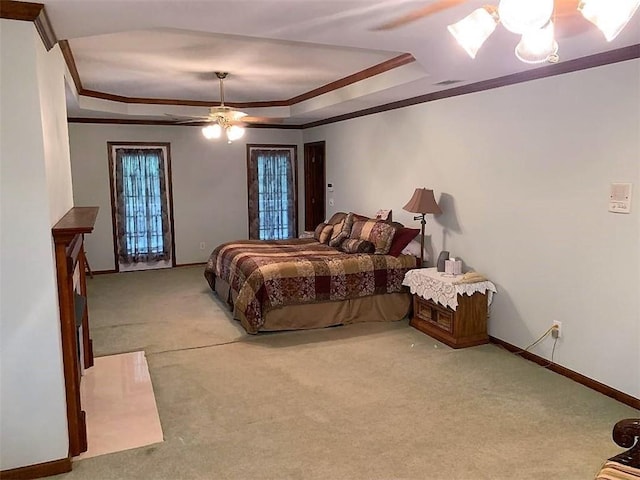 carpeted bedroom with a raised ceiling and ceiling fan