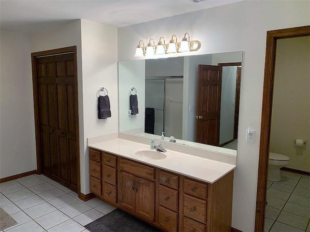 bathroom with toilet, vanity, and tile flooring