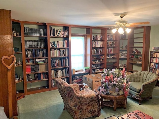 living area featuring carpet and ceiling fan