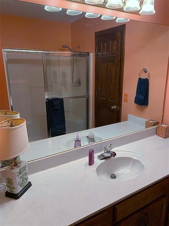 bathroom featuring vanity and a shower with shower door