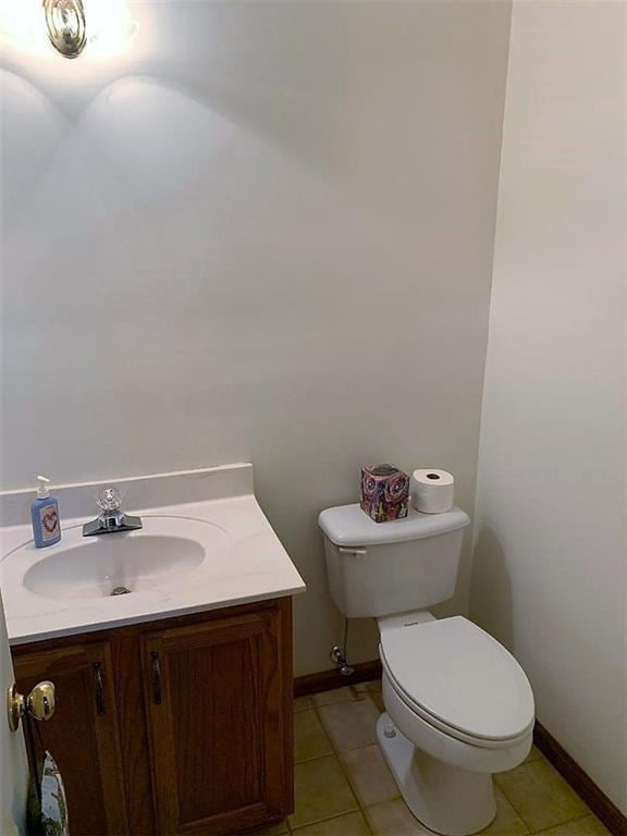 bathroom featuring toilet, vanity, and tile flooring