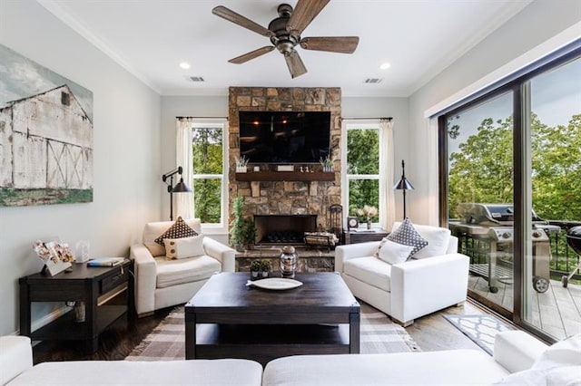 living room featuring plenty of natural light, visible vents, and crown molding