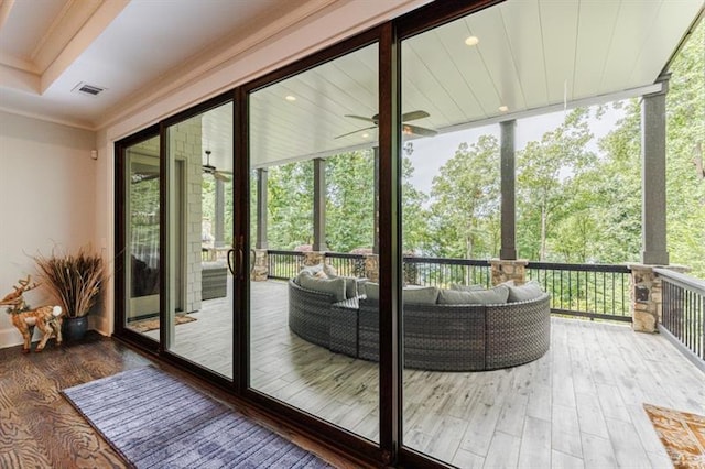 doorway featuring floor to ceiling windows, visible vents, wood finished floors, and ornamental molding