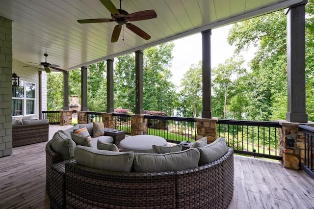 wooden terrace with a ceiling fan and an outdoor hangout area