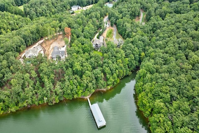 birds eye view of property with a water view and a wooded view