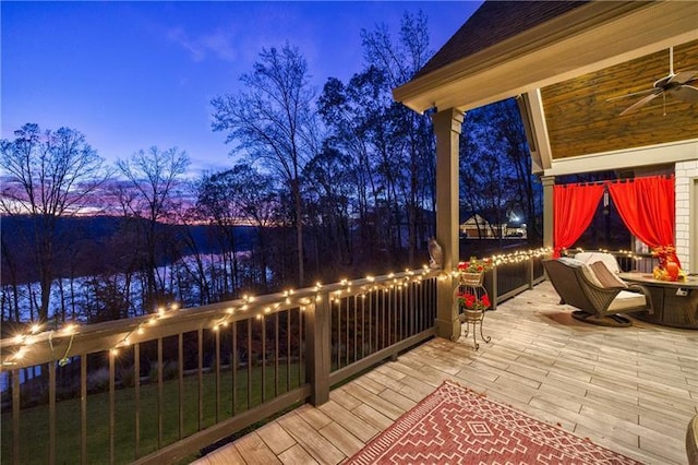 deck at dusk featuring a ceiling fan