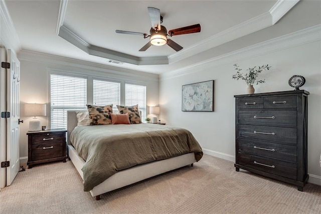 bedroom featuring light colored carpet, a ceiling fan, baseboards, ornamental molding, and a tray ceiling