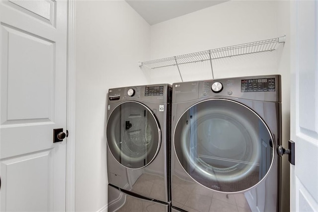 laundry room with laundry area, tile patterned flooring, and washing machine and dryer