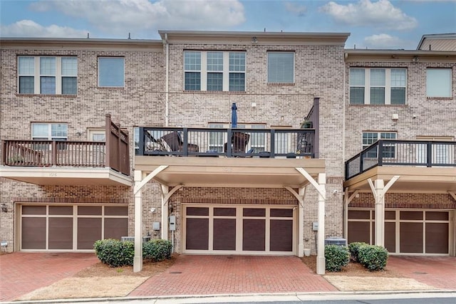 view of front of house featuring driveway, brick siding, and an attached garage