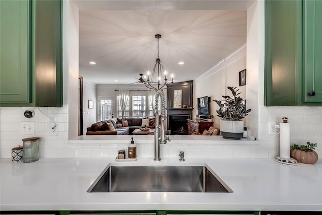 kitchen featuring open floor plan, light countertops, a sink, and green cabinetry