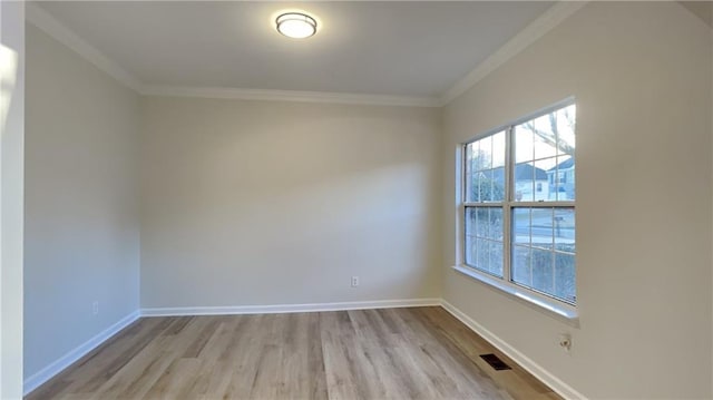 spare room with ornamental molding and light hardwood / wood-style flooring