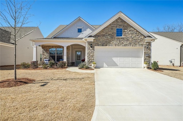 craftsman-style house featuring a garage, concrete driveway, covered porch, and stone siding