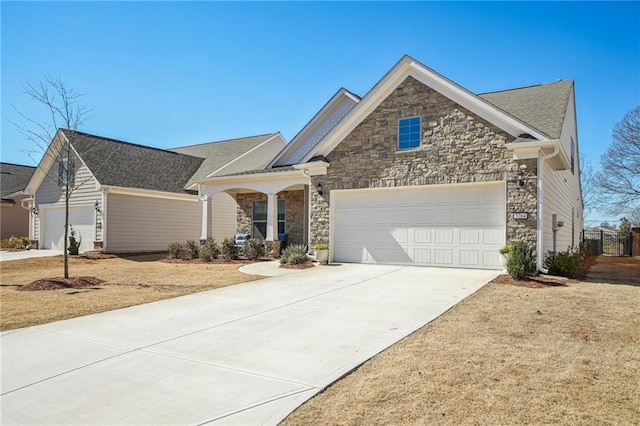 view of front facade featuring stone siding, driveway, and an attached garage