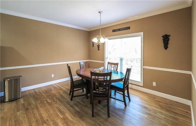 dining area with baseboards, crown molding, and wood finished floors