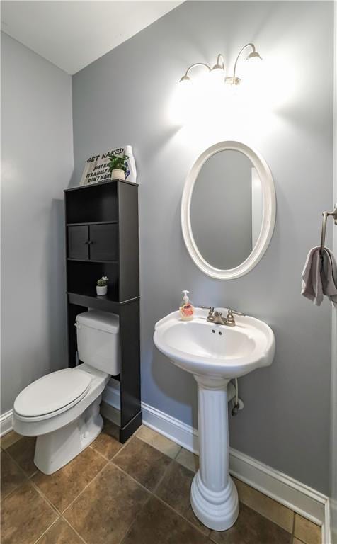 bathroom with tile patterned flooring, toilet, and baseboards