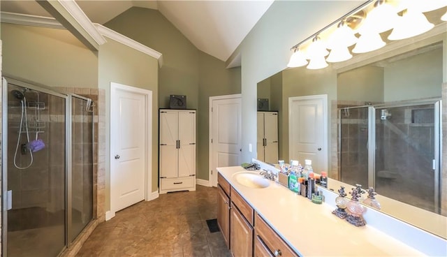 bathroom with vaulted ceiling, a shower stall, and vanity