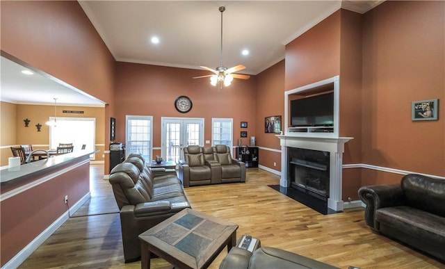 living area with ornamental molding, french doors, and wood finished floors