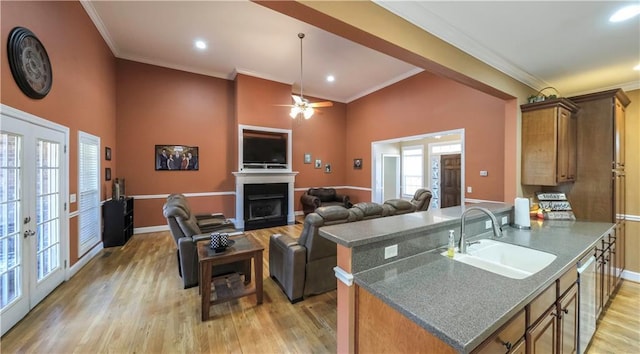 kitchen with light wood finished floors, french doors, a fireplace, and a sink