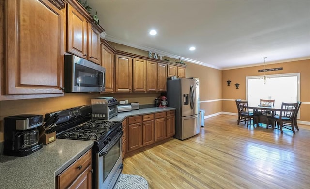 kitchen featuring light wood finished floors, brown cabinetry, hanging light fixtures, stainless steel appliances, and crown molding