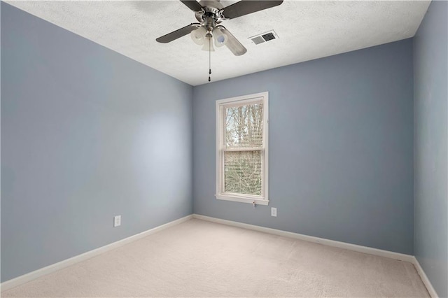 carpeted spare room featuring ceiling fan and a textured ceiling