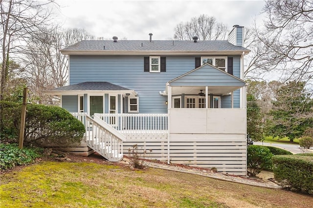 rear view of house with ceiling fan and a lawn