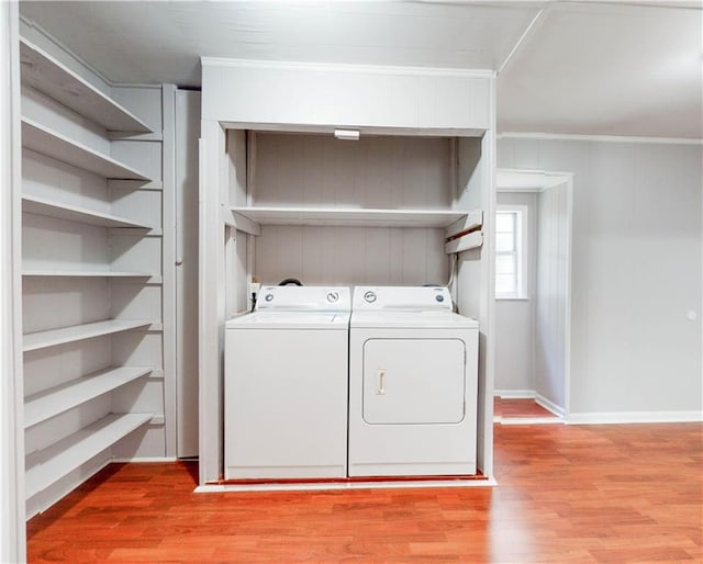 washroom featuring crown molding, washer and clothes dryer, and light wood-type flooring