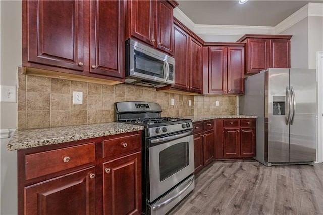 kitchen featuring tasteful backsplash, crown molding, light stone countertops, and appliances with stainless steel finishes