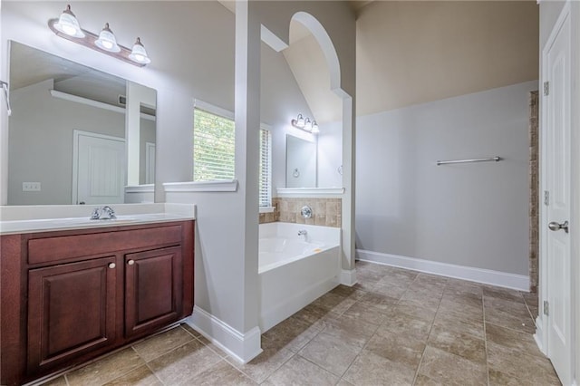 bathroom with lofted ceiling, vanity, and a bathing tub