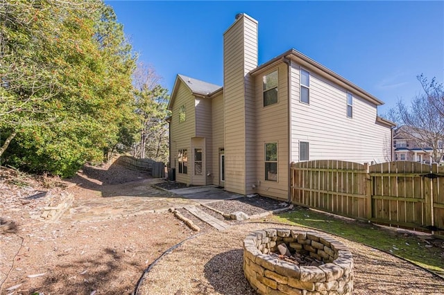 rear view of house with a patio area and a fire pit